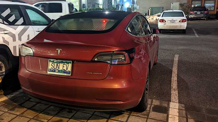 Roter Tesla mit Wunschkennzeichen "SUN EV", geparkt