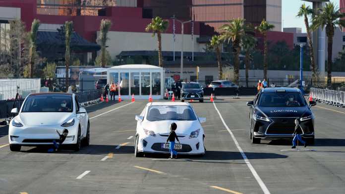 Der Lidar-Hersteller Luminar lässt gerne Kinderdummys von Konkurrenz-Produkten überfahren: In Las Vegas im Januar 2022 überrollt links ein Tesla ohne Lidar den Dummy, der plötzlich hinter der Autoattrappe in der Mitte hervorkommt., Charles Sykes / AP Images for Luminar Technologies