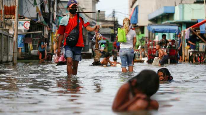 In einer Marktstraße der indonesischen Hauptstadt Jakarta spielen Kinder im Wasser. Überflutungen, wie hier im November 2021, gehören für sie zum Alltag. Die Regierung plant bereits eine Umsiedlung der Hauptstadt., REUTERS/Willy Kurniawan