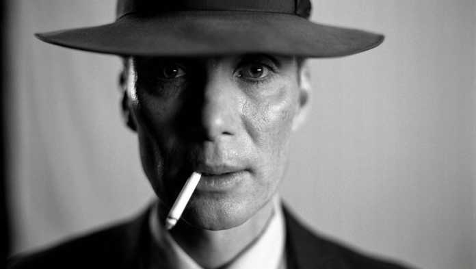 Der Schauspieler Cillian Murphy in seiner Rolle als Robert Oppenheimer. Ein Schwarz-Weiß-Porträt eines Mannes mit Hut und Zigarette im Mundwinkel.