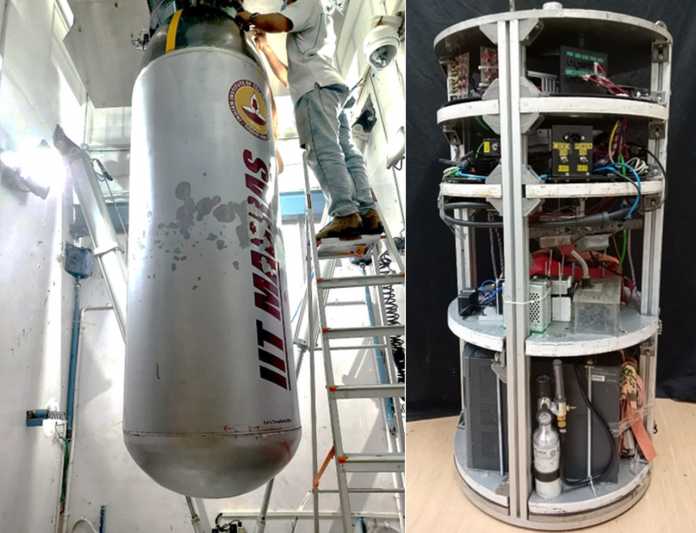 left: cylindrical metal tank hanging from a ceiling, being filled by a person on a ladder;  right: a cylindrical shelf holding various apparatuses to be inserted into the tank