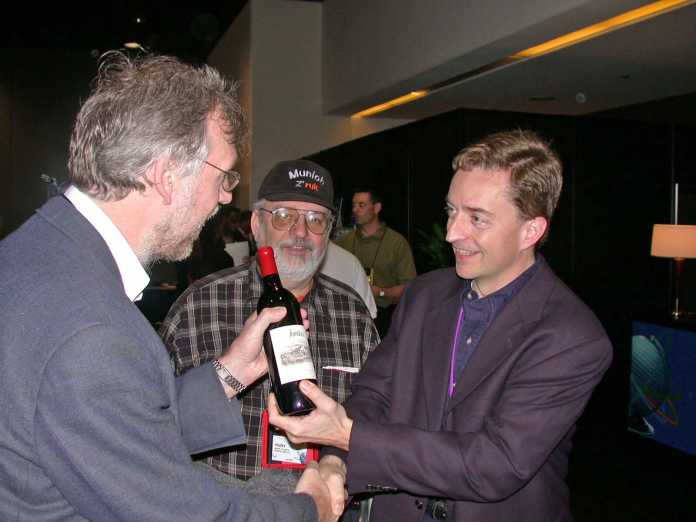 c’t-Redakteur Andreas Stiller nimmt seinen Wettgewinn vom heutigen Intel-Chef Pat Gelsinger entgegen: eine Flasche Wein., 