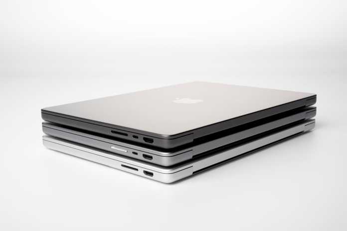 Oto kolory MacBooków Pro: srebrny na dole, gwiezdna szarość na środku i gwiezdna czerń na górze. 