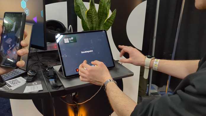 Männlicher Arm, mit Smartwatch bestückt, bedient ein Tablet, ohne es zu berühren.