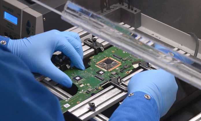 Ein Experte von TechInsights zerlegt das Huawei-Notebook Qingyun L540, um den 5-Nanometer-Chip Kirin 9006C zu entnehmen. Das Mikroskop soll klären, wer ihn gefertigt hat., TechInsights