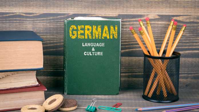Gemütlich aussehender Arbeitsplatz mit einem Buch auf dem "German" steht