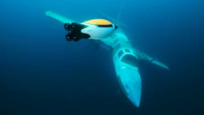 Quadroin-Unterwasserroboter im Wasser vor einem Flugzeugwrack.