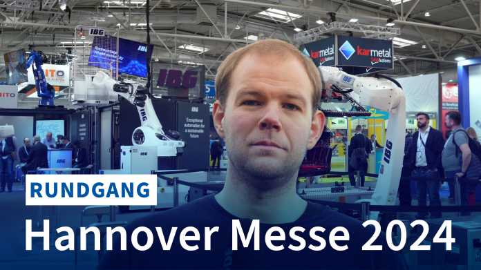 Video. Das Standbild zeigt Jan Mahn in einer Messehalle, hinter ihm große Industrieroboter; Schrift: "Rundgang Hannover Messe 2024"