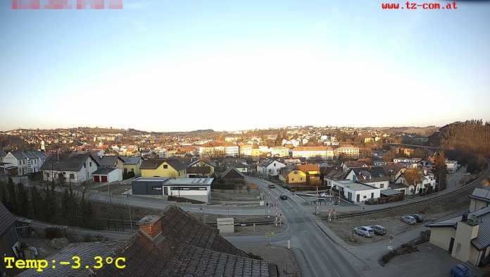 Morgendliches Webcam-Bild mit Straßen, einem Bahnübergang und diversen Liegenschaften