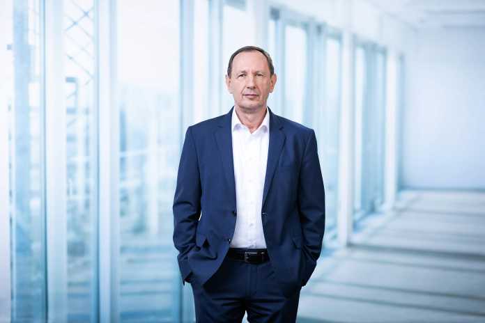 The head of BWI stands in front of a window in the corridor of an office building.