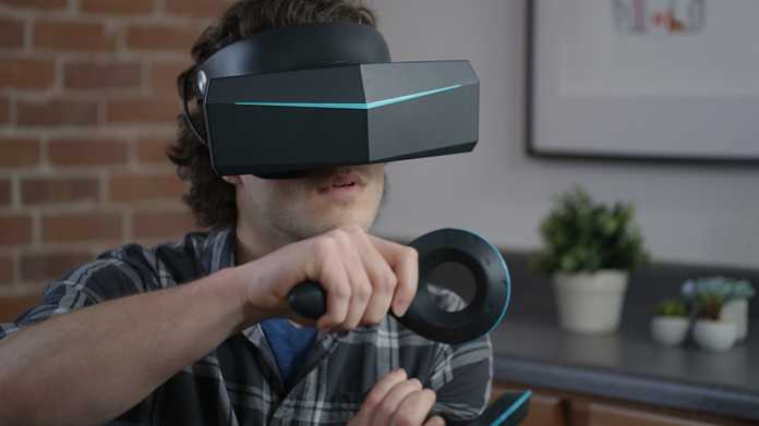 Ein Mann mit klobiger Pimax-VR-Brille und Controllern.