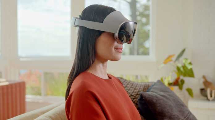 Eine Frau sitzt im Wohnzimmer mit Samsung Galaxy XR im Gesicht.