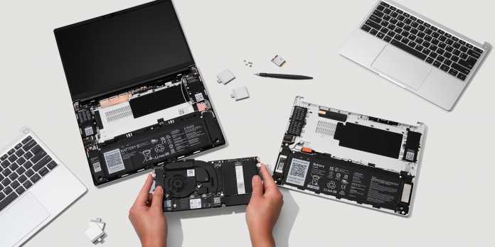 Mann schraubt an einem Notebook