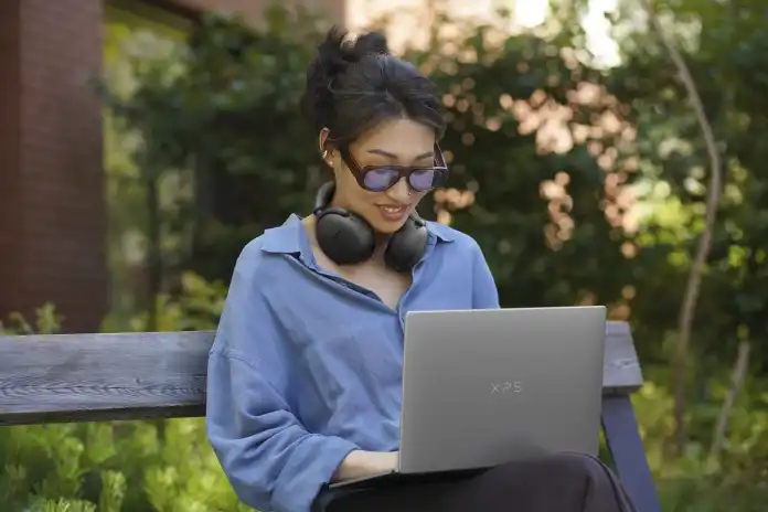 Frau bedient Dell XPS 13 auf eriner Parkbank