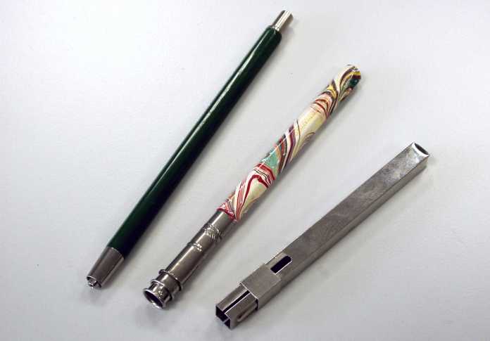 Drei schmale Stiftgehäuse: Ein grüner Metall-Fallminenstift, eine Bleistiftverlängerung und ein silbern glänzender Pastellkreidenhalter.