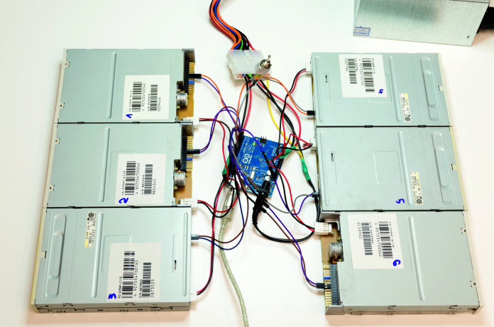 Sechs Diskettenlaufwerke, um einen Arduino verteilt.