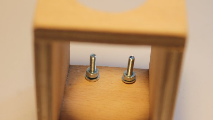 Zwei Schrauben ragen aus einem Stück Holz.