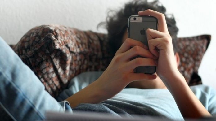 Jugendlicher mit iPhone