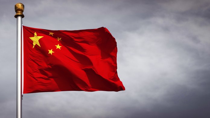 Xi Jinping an Tisch mit Wimpel der VR China