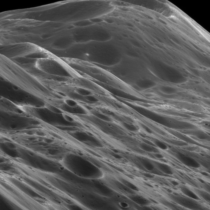 Großaufnahme des Äquatorialkamms von Iapetus durch die Cassini-Sonde aus 3870 Kilometern Entfernung. Die Bildauflösung beträgt ca. 23 Meter pro Pixel. Über der Bildmitte sieht man eine kleine helle Stelle, wo ein Meteoriteneinschlag das unter dem Staub liegende Eis freigelegt hat. Die starke Verkraterung deutet auf ein hohes Alter hin.