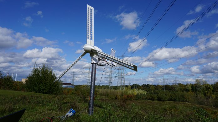 Kleine, weiße Windmühle vor blauem Himmel.