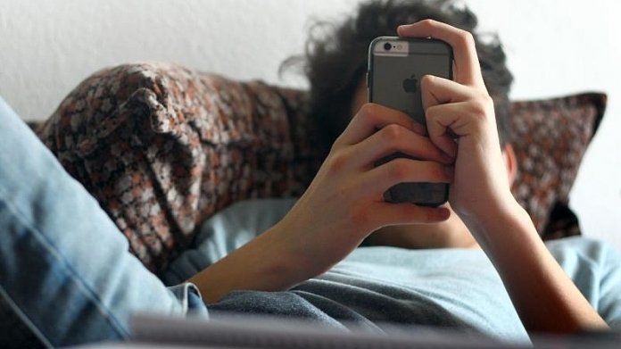 Jugendlicher mit iPhone