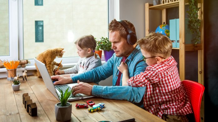 Vater im Homeoffice mit Kindern