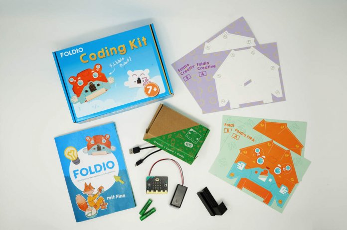 Inhalt des Foldio-Sets: vier Bastelbögen, ein Buch sowie ein BBC micro:bit mit Batteriehalter und Batterien.