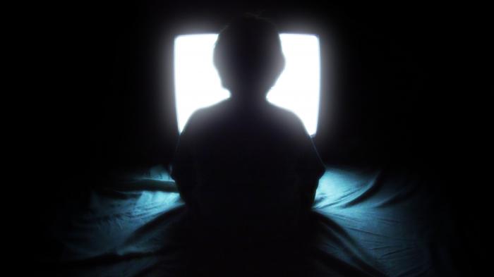 Kind sitzt vor Fernseher