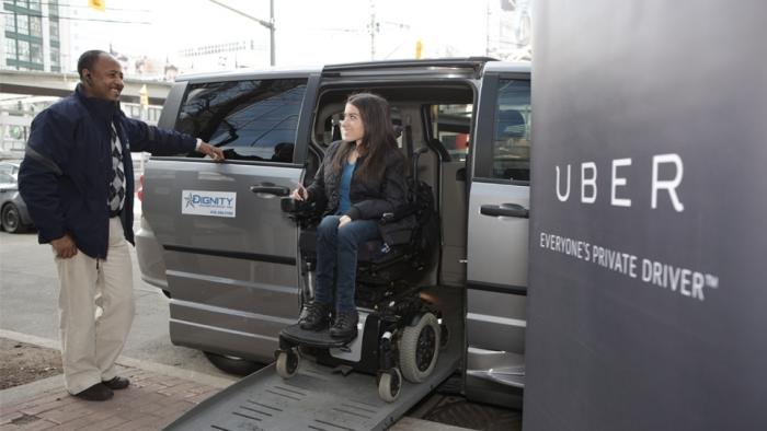 Rolli-Fahrerin gleitet über Rampe aus Uber-Van