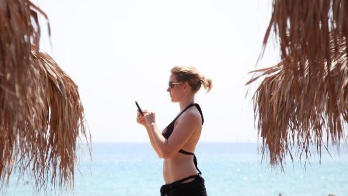 Mit dem Handy am Strand