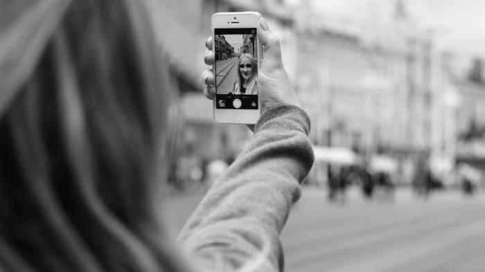 Dame streckt Arm aus und macht Selfie