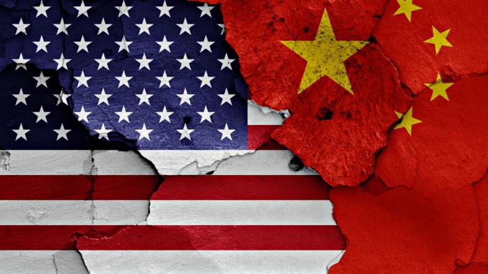 Eine Gruppe Mänchen stellt eine US-Fahne auf, die andere eine Fahne der VR China