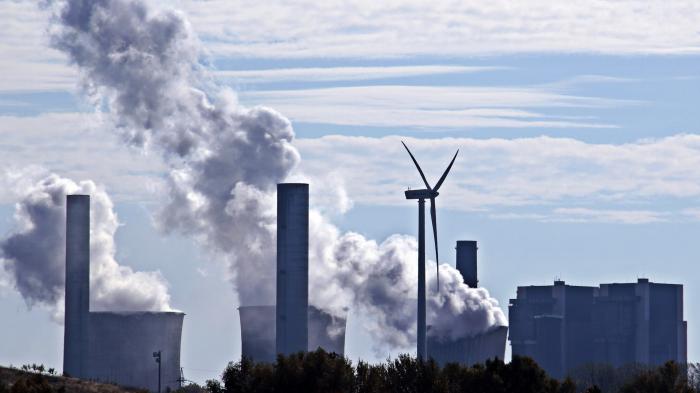 Windrad, dahinter Kühltürme eines Kohlekraftwerks