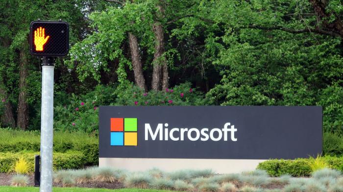 Rote Fußgängerampel, daneben ein Schild mit Microsoft-Logo und -Schriftzug