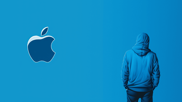Person in Kaputzenpullover vor einem Apple-Logo