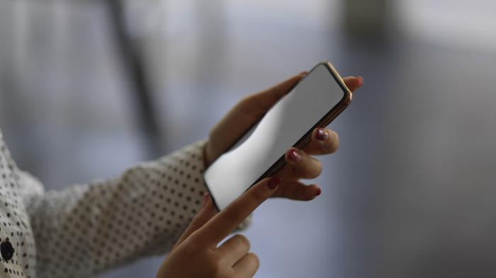 Frauenhand an Smartphone