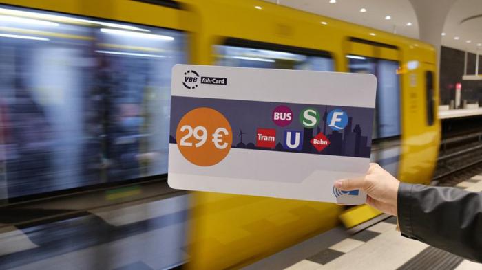 Vor einer fahrenden S-Bahn wird ein überdimensioniertes Ticket ins Bild gehalten