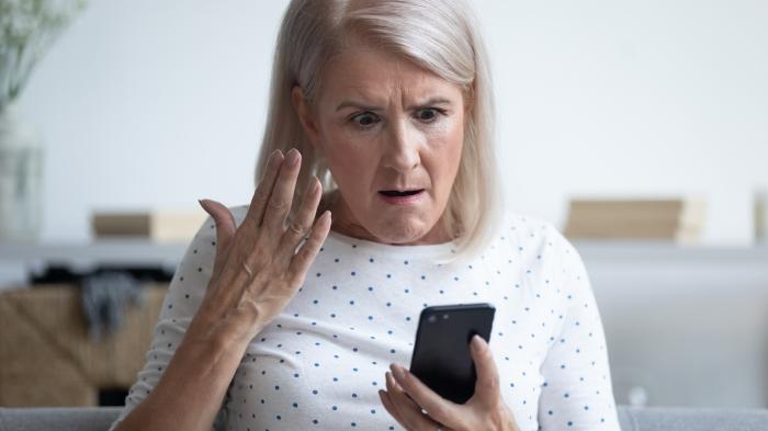 Frau mit Handy ärgert sich