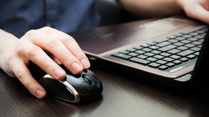 Hand auf Maus, die andere auf einer Tastatur