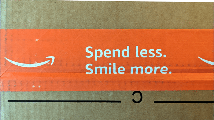 Detailaufnahme eines Amazon-Pakets. Auf dem orangen Klebeneband steht neben dem Amazon-Logo 