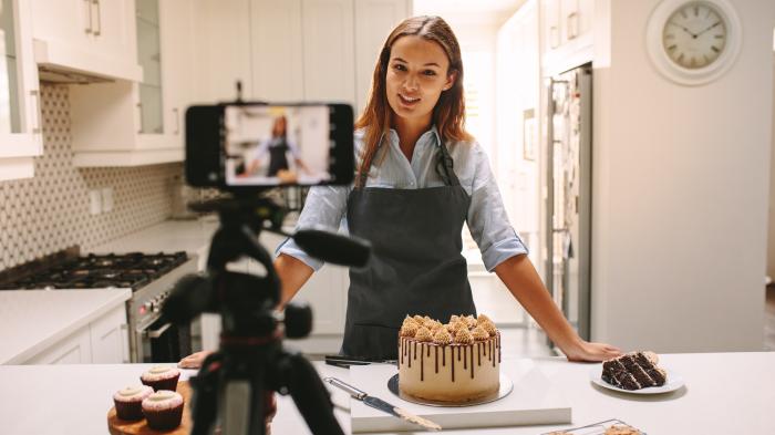 Eine Frau filmt sich beim Backen. 