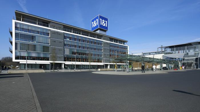 Bürogebäude, darauf ein blauer Würfel mit Aufschrift 