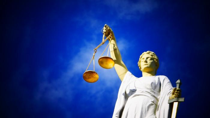 Statue der Justicia vor blauem Himmel.