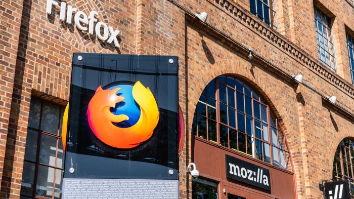 Firefox-Schritzug an Gebäude, davor Stele mit Firefox-Logo