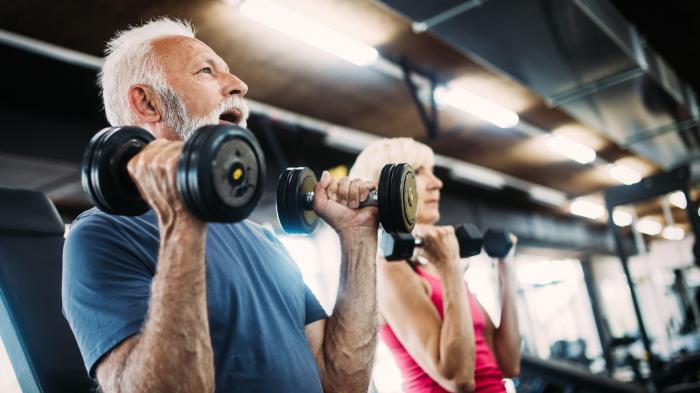 Fröhliche Senioren, die im Fitnessraum trainieren, um fit zu bleiben