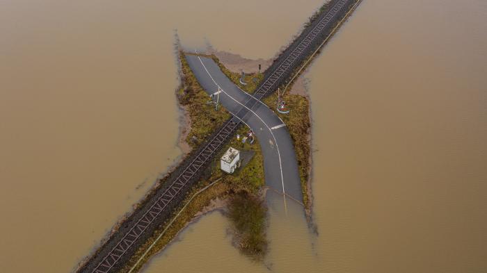 Überschwemmte Straße, die eine Bahntrasse überquert, Deutschland 2021.