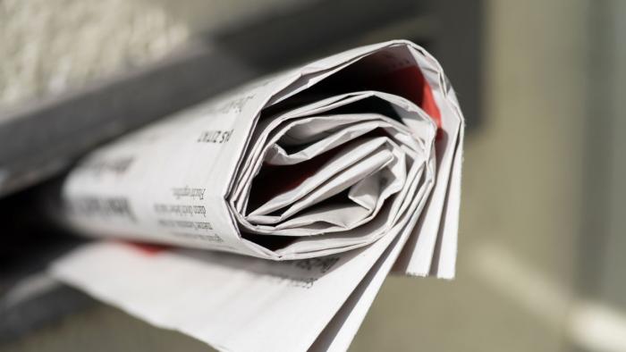Zusammengerollte Zietung im Briefkastenschlitz