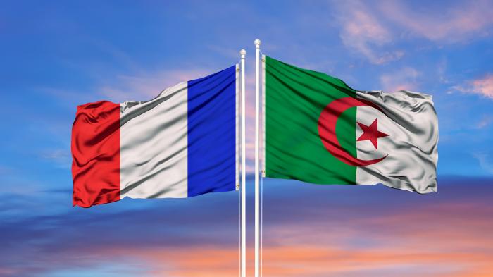 Flagge Frankreichs und Algeriens die in jeweils andere Richtungen wehen