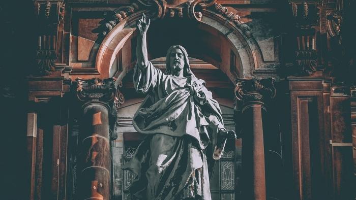 Symbolbild zeigt Christus-Figur mit erhobener Hand in einer Kathedrale
